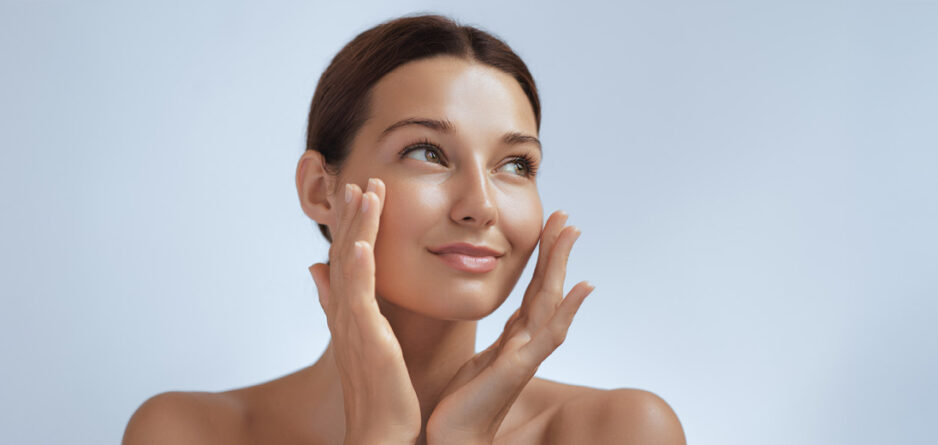 A woman with her hands on her face, applying face cream thinking about urea in moisturisers vs. other ingredients