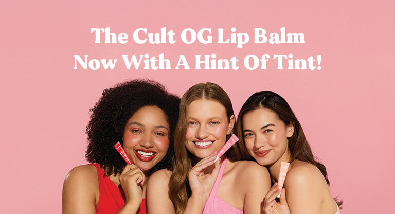 Promotional graphics with white text "The Cult OG Lip Balm now with a hint of tint!" on a light pink background including three female models, each holding a variant of the Dermal Therapy Tinted Lip Balm.
