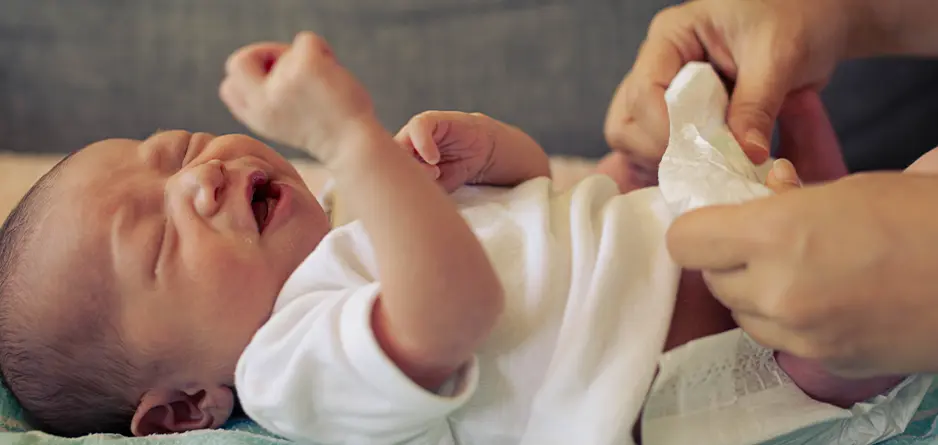 Crying baby being treated for nappy rash