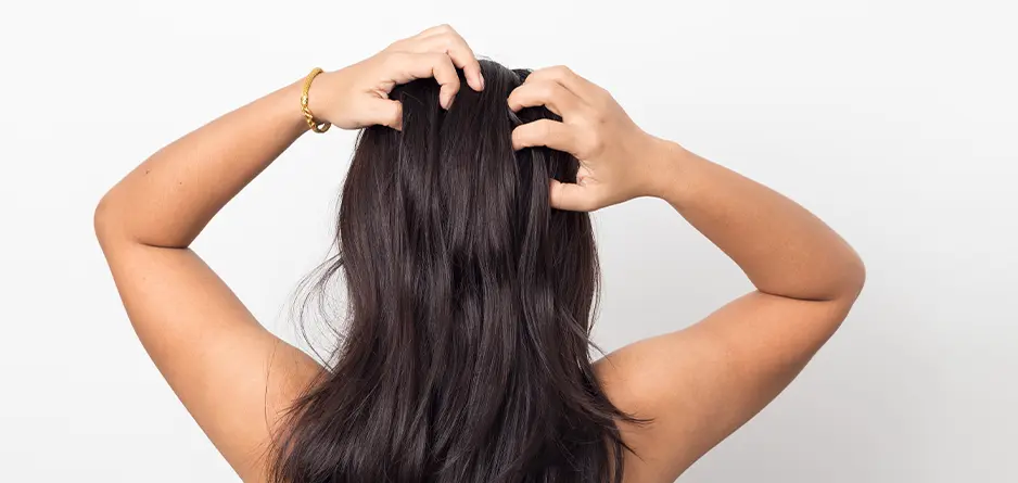 Woman feeling itchy scalp