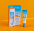 Dermal Therapy Lip Balm SPF50+ box and tube displayed on an orange background.