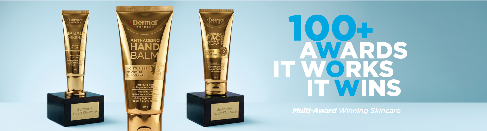Three Dermal Therapy products including Lip Balm Original, Anti-Ageing Hand Balm and Overnight Face Repair Cream displayed on award trophy bases beside the text “100+ Awards It Works It Wins” and “Multi-Award Winning Skincare”.